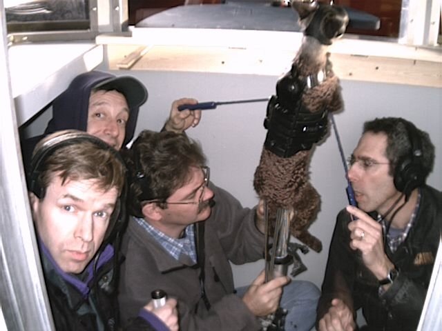 Four puppeteers operating the Mr. Tinkles puppet from inside a guard booth